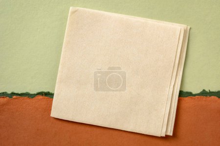Téléchargez les photos : Serviette vierge contre paysage abstrait en papier dans les tons vert et orange - en image libre de droit