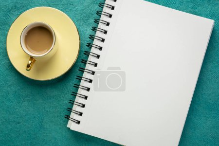 Photo for Blank spiral sketchbook against textured paper with a cup of coffee, desktop flat lay - Royalty Free Image
