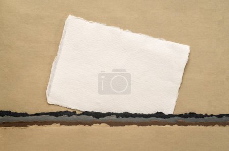 Foto de Pequeña hoja de blanco blanco papel de trapo Khadi de la India contra el paisaje abstracto en tonos de tierra - Imagen libre de derechos