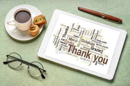 Photo for Thank you in different languages - word cloud on a  digital tablet with a cup of coffee - Royalty Free Image