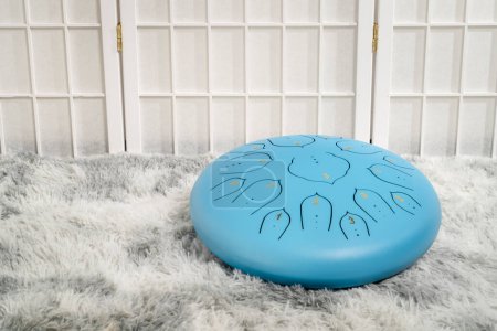 Photo for Blue steel tongue drum on a fluffy rug - Royalty Free Image