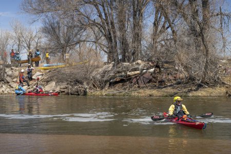 Téléchargez les photos : Evans, CO, États-Unis - 1er avril 2023 : Les pagayeurs transportent des kayaks et des canots sur un barrage de dérivation lors d'un voyage de pagaie printanier sur la rivière South Platte au Colorado. - en image libre de droit