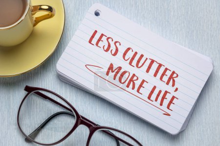 less clutter, more life - decluttering, minimalism and simplicity concept, handwriting on an index card