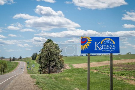 Foto de Kansas le da la bienvenida - señal de bienvenida al borde de la carretera con una popular frase latina ad astra per aspera (a través de dificultades a las estrellas), conducción y concepto de viaje - Imagen libre de derechos