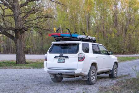 Photo for Dalton, MO, USA - April 23, 2023: Toyota 4Runner SUV with a performance stand up paddleboard (Starboard Waterline) on roof racks at a shore of the MIssouri River in spring scenery, aerial view. - Royalty Free Image