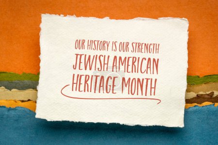 Our history is our strength - Jewish American Heritage Month - handwriting on a sheet of watercolor paper against abstract landscape, reminder of cultural event
