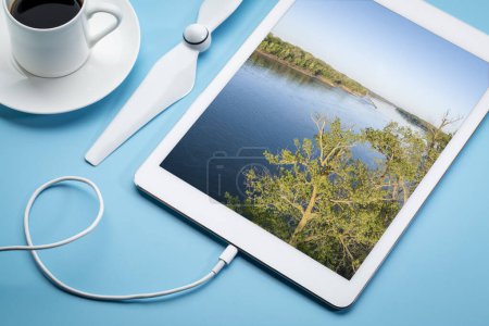 Téléchargez les photos : Lever de soleil printanier sur la rivière Missouri à Dalton Bottoms - image aérienne affichée sur une tablette numérique avec une tasse de café - en image libre de droit