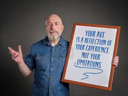 Photo for Your age is a reflection of your experience, not your limitations - inspirational message on a white board held bey a happy and confident senior man - Royalty Free Image