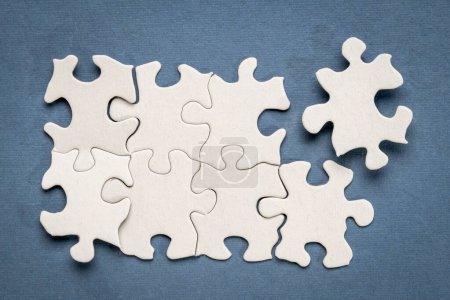 Téléchargez les photos : Vue du haut du puzzle blanc inachevé sur fond bleu, complétant une tâche ou résolvant un concept de problème - en image libre de droit