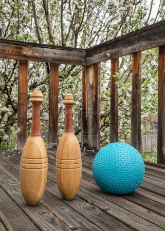 Foto de Par de clubes de ejercicio indios y una pelota de medicina pesada en una cubierta de madera - concepto de fitness funcional - Imagen libre de derechos