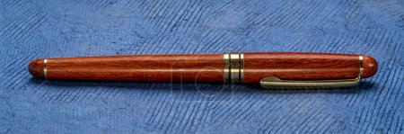 Photo for Retro, elegant, rosewood ballpoint pen on a textured bark paper - Royalty Free Image