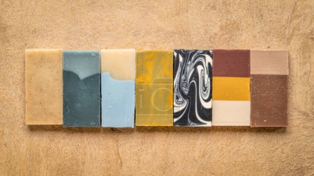 Téléchargez les photos : Variété de 7 barres de savon artisanales biologiques sur un papier écorcé texturé - en image libre de droit