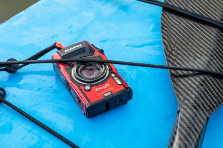 Téléchargez les photos : Fort Collins, CO, USA - Le 6 juin 2023 : Caméra Olympus Stylus Tough TG-5 compacte et imperméable sur un pont mouillé d'une planche à pagaie debout. - en image libre de droit