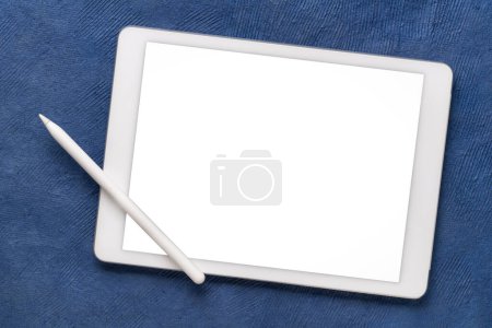 Téléchargez les photos : Maquette de tablette numérique avec crayon électronique et écran isolé vierge (chemin de coupure inclus) contre papier d'art texturé ablue - en image libre de droit