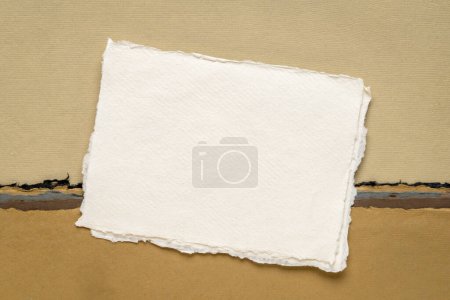 Téléchargez les photos : Petite feuille de papier blanc blanc blanc Khadi chiffon de l'Inde contre paysage abstrait dans les tons de la terre - en image libre de droit