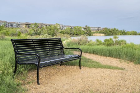 Photo for Metal bench and trail on a lake shore - Boedecker Bluff Natural Area in Loveland Colorado - Royalty Free Image