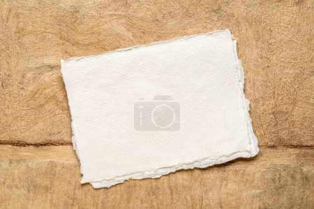 Foto de Hoja de papel de trapo blanco Khadi en blanco contra el paisaje abstracto en tonos tierra - Imagen libre de derechos
