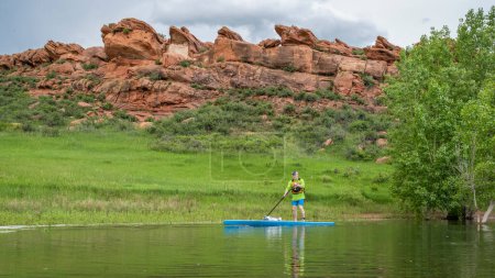 Photo for Senior male paddler on a touring stand up paddleboard on lake in Colorado foothills - Horsetooth Reservoir near Fort Collins - Royalty Free Image