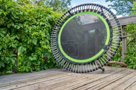Téléchargez les photos : Mini trampoline pour l'exercice de remise en forme et le rebond dans un patio arrière-cour, décors d'été - en image libre de droit