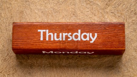 Téléchargez les photos : Jeudi et lundi texte sur bloc de bois contre papier d'écorce fait à la main dans des tons de terre, concept de calendrier - en image libre de droit