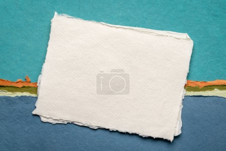 Foto de Pequeña hoja de blanco blanco papel de trapo Khadi de la India contra el paisaje abstracto en tonos azules - Imagen libre de derechos