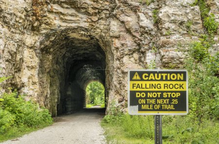 Téléchargez les photos : Tunnel MKT sur Katy Trail à Rocheport, Missouri avec un panneau d'avertissement de chutes de roches. 237 mile piste cyclable s'étendant à travers l'état du Missouri est converti d'un ancien chemin de fer. - en image libre de droit