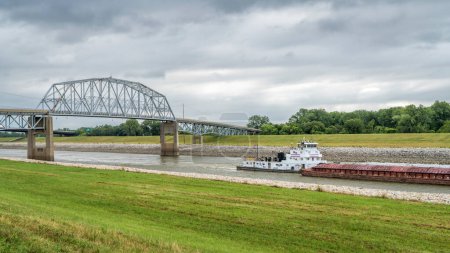 Photo for Towboat with barges is passing under a bridge on the Chain of Rocks Canal of MIssissippi River above St Louis - Royalty Free Image