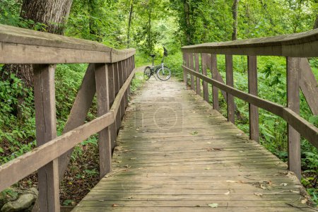 Photo for Folding bike and footbridge - Katy Trail (side nature trail) near Rocheport, Missouri, in summer scenery - Royalty Free Image