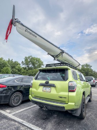 Photo for St Charles, MO, USA - August 4, 2023: Toyota 4runner, TRD pro model, SUV with 700x sea kayak on roof racks parked among other cars. - Royalty Free Image