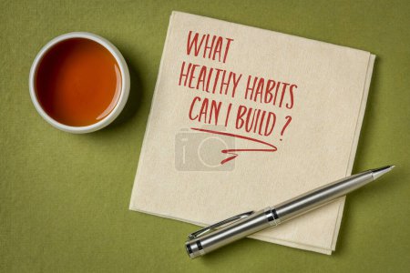 Photo for What healthy habits can I build? Self reflection question on a napkin with tea. Healthy lifestyle and personal development concept. - Royalty Free Image