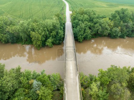 Photo for Road and bridge over flooded Lamine River with floating debris, aerial view at Roberts Bluff access in Missouri - Royalty Free Image