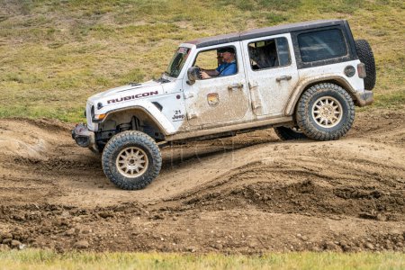 Photo for Loveland, CO, USA - August 26, 2023: Jeep Wrangler, Rubicon model, on a muddy and bumpy training drive off-road course. - Royalty Free Image