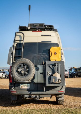 Photo for Loveland, CO, USA - August 27, 2023: Back of Mercedes Sprinter 4x4 camper van with a spare tire, roof ladder and rack with different gear attached. - Royalty Free Image