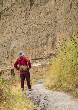 Foto de Senderista masculino senior en el sendero Saddle Rock Trail que conduce a la cumbre del Monumento Nacional Scotts Bluff a finales del verano - Imagen libre de derechos