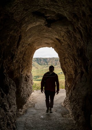 Foto de Silueta de un caminante masculino caminando a través de un túnel en la Saddle Rock Trail que conduce a la cumbre del Monumento Nacional Scotts Bluff - Imagen libre de derechos