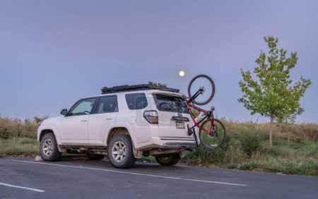 Photo for Windsor, CO, USA - September 27, 2023: Toyota 4runner SUV with Trek touring gravel bike mounted with  Hornet suction cup racks by Seasucker on a rear window. - Royalty Free Image