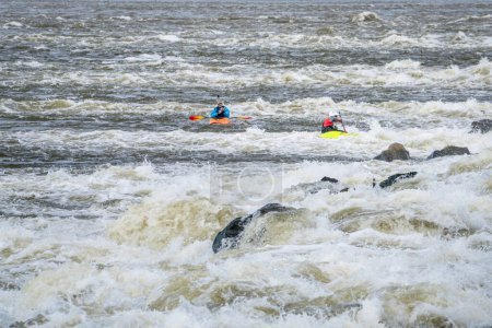Photo for Two whitewater kayakers playing and training below Low Water Dam on the Mississippi River at Chain of Rocks near St Louis, Missouri - Royalty Free Image