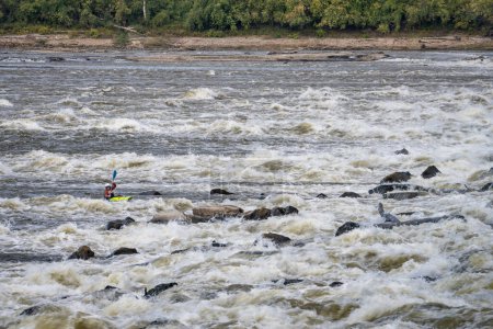 Foto de Granite CIty, Il, Estados Unidos - 8 de octubre de 2023: Un solitario kayak de aguas bravas está jugando y entrenando por debajo de la Presa de Baja Agua en el Río Mississippi en Chain of Rocks cerca de St Louis, Missouri. - Imagen libre de derechos