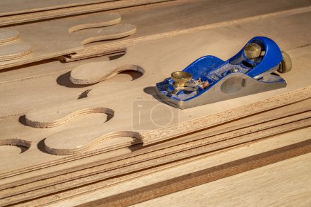 Photo for Block plane and narrow panels of okoume plywood with puzzle joints from a stitch-and-glue boat building kit - Royalty Free Image