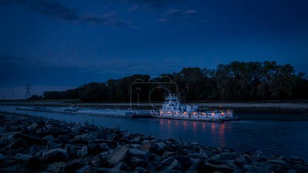 Photo for Towboat with barges on Chain of Rock Bypass Canal of Mississippi River above St Louis, night scenery at dawn - Royalty Free Image