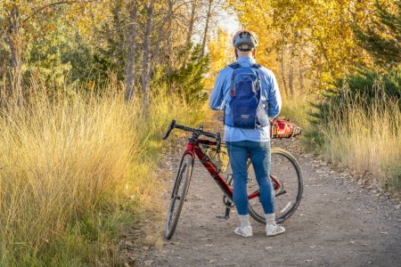 Foto de Ciclista masculino senior con una bicicleta de grava itinerante en un sendero en el norte de Colorado en el paisaje de otoño - Imagen libre de derechos