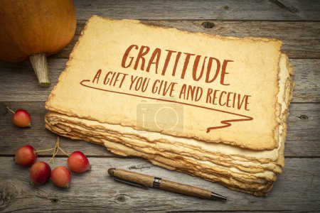 Foto de Gratitud - un regalo que das y recibes, Tema de la fiesta de Acción de Gracias, escritura a mano en un papel áspero hecho a mano con manzanas de calabaza y cangrejo - Imagen libre de derechos