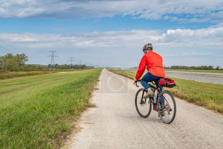 Photo for Male cyclist is riding a gravel touring bike - biking on a levee trail along Chain of Rocks Canal near Granite City in Illinois - Royalty Free Image