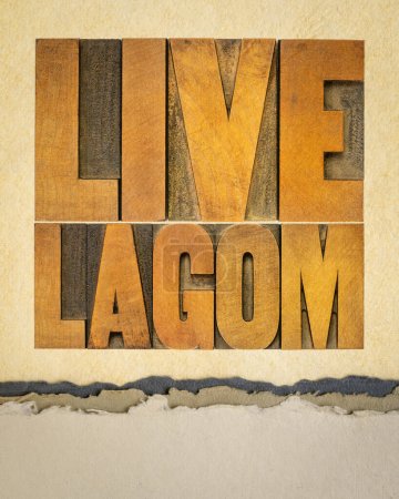 Téléchargez les photos : Affiche lagom live - mot abstrait en typographie vintage type bois sur papier d'art, style de vie équilibré suédois et concept de modération - en image libre de droit
