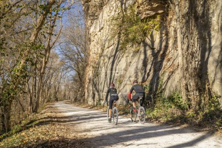 Photo for Rocheport, MO, USA - Nevember 18, 2023 - A couple of cyclists on Katy Trail in late November scenery.with a rocky cliff. - Royalty Free Image