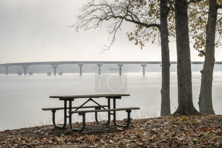 Foto de Mesa de picnic en Colbert Ferry Park, Natchez Trace Parkway con vistas al puente sobre el río Tennessee de Tennessee a Alabama, nebulosa mañana de noviembre - Imagen libre de derechos