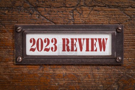 Foto de 2023 revisión - una etiqueta en el gabinete de archivo de madera grunge. Evaluación, resumen y revisión del año transcurrido. - Imagen libre de derechos