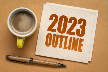 Téléchargez les photos : 2023 année esquisse texte sur une serviette avec une tasse de café, concept de revue des affaires de fin d'année - en image libre de droit