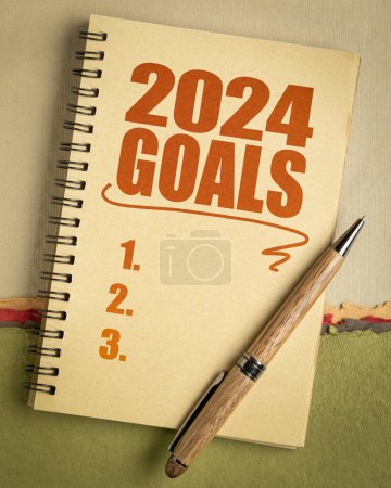 Téléchargez les photos : Liste des buts 2024 dans un carnet avec stylo, fixant les buts et résolutions du Nouvel An - en image libre de droit
