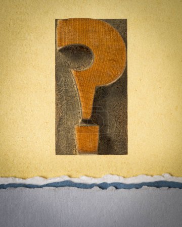Foto de Signo de interrogación en tipografía vintage tipo madera contra papel de arte, preguntas y concepto de incertidumbre - Imagen libre de derechos